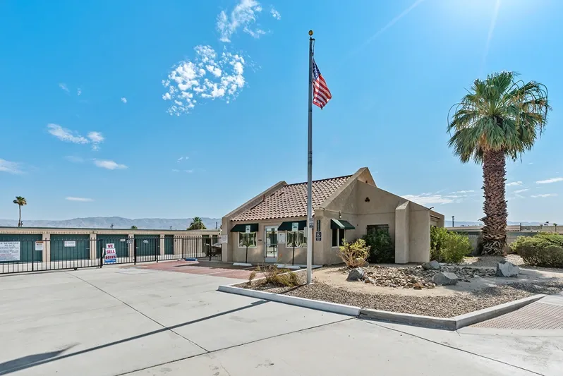 Flag, main gate, and office of a storage facility.