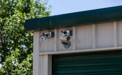 Two outdoor security cameras at a storage facility.