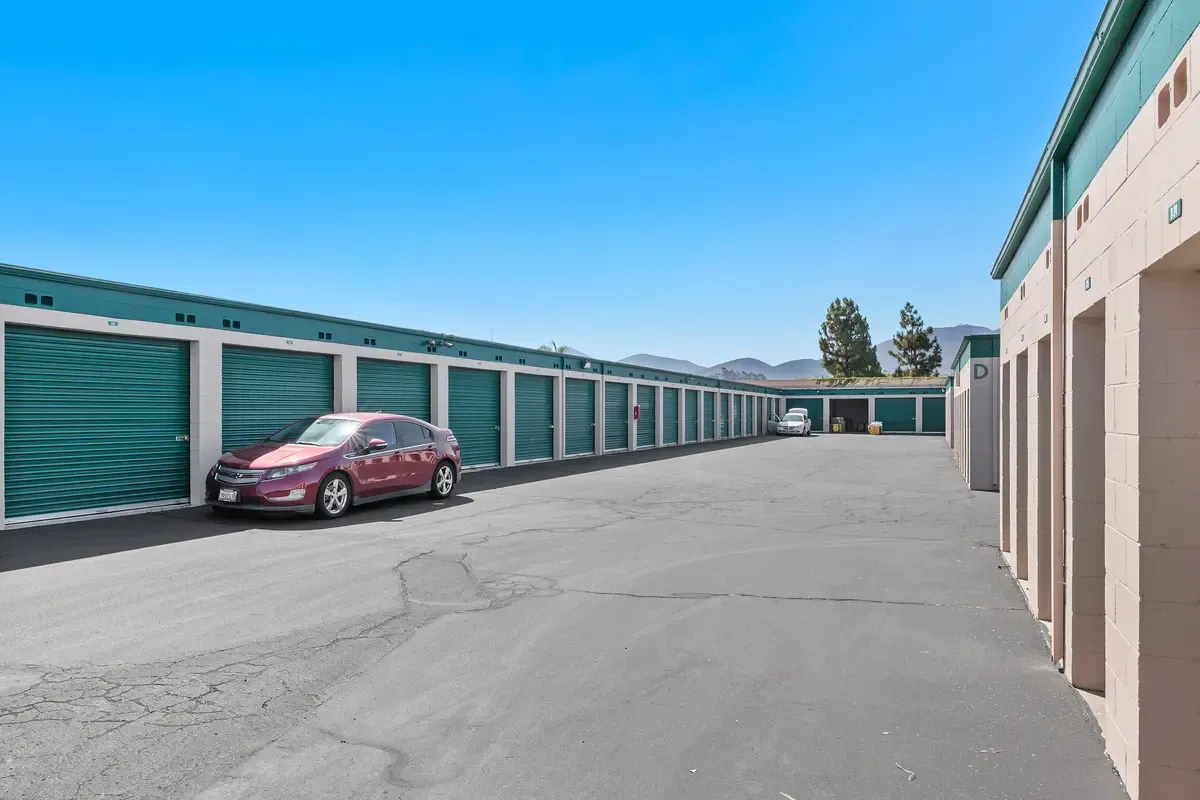 Car parked near outdoor green storage units.
